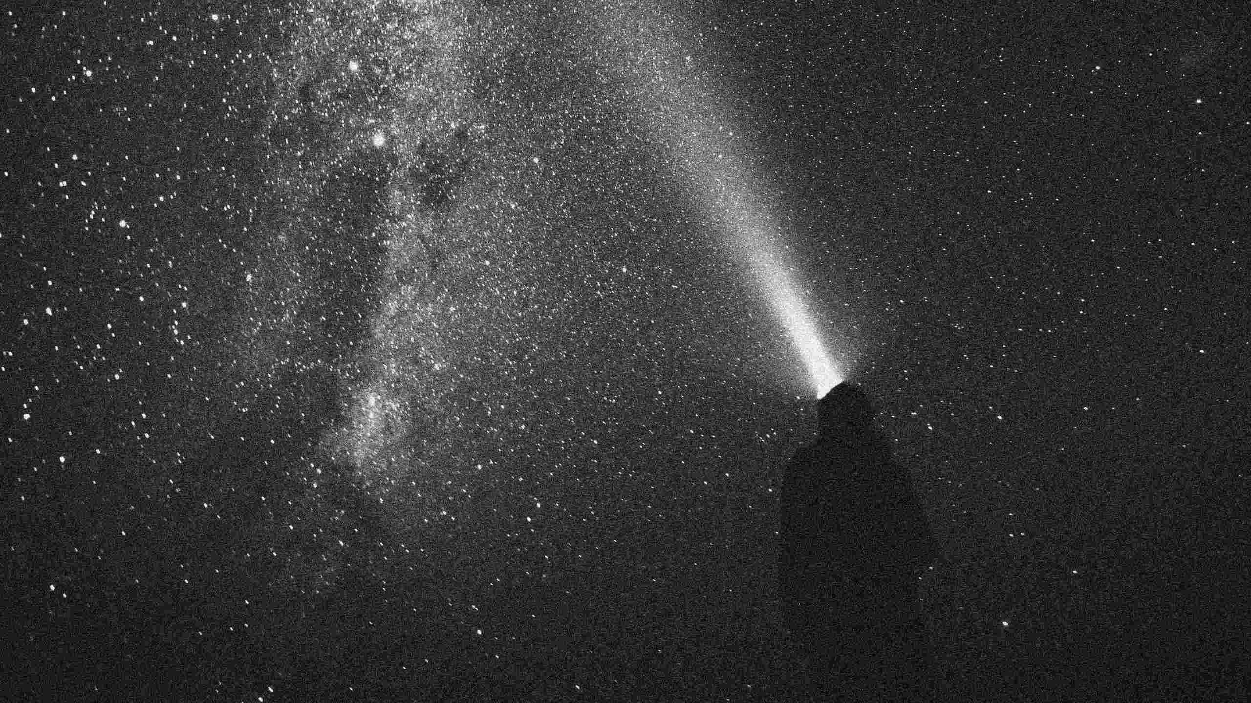 B2IMPACT - Person with torch in front of a starry sky